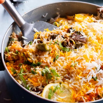 Beef Biryani in a pot with a spoon in it