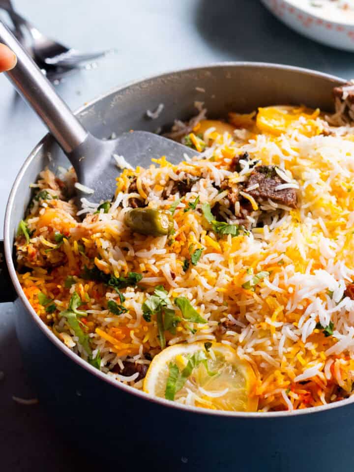 Beef Biryani in a Pot with a serving spoon