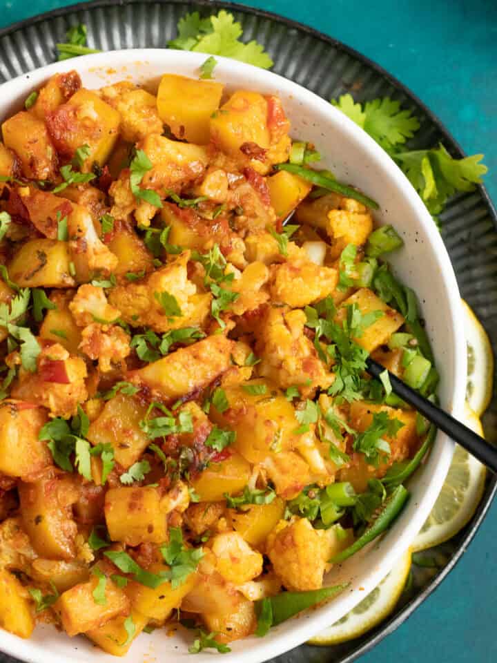 Pakistani Aloo Gobi Sabzi in a dish with a spoon in it