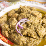 Hara Masala Chicken in a dish with onions and a sliced chili