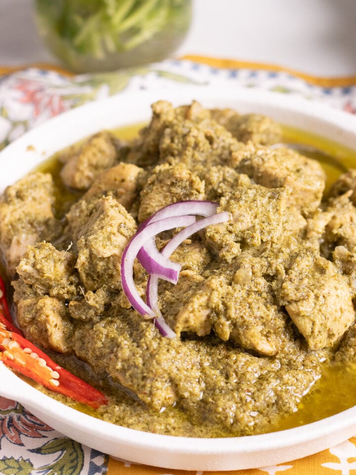 Hara Masala Chicken in a dish with onions and a sliced chili