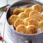 A ¾ shot of a tin of french hearts with some christmas decor in the background