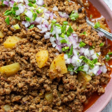 Aaloo Keema or Keema Aloo top down view garnished with onions and cilantro