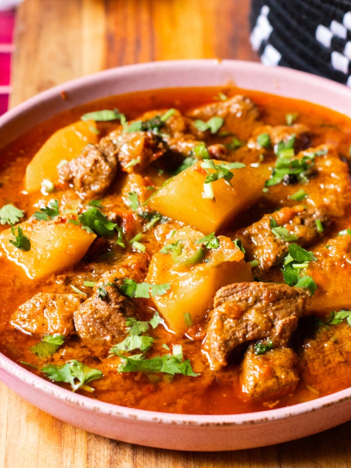A bowl with Aloo Gosht, a meat and potato stew.