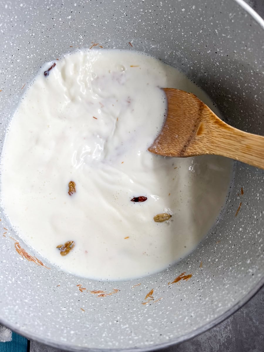 milk bubbling and being stirred in a pot