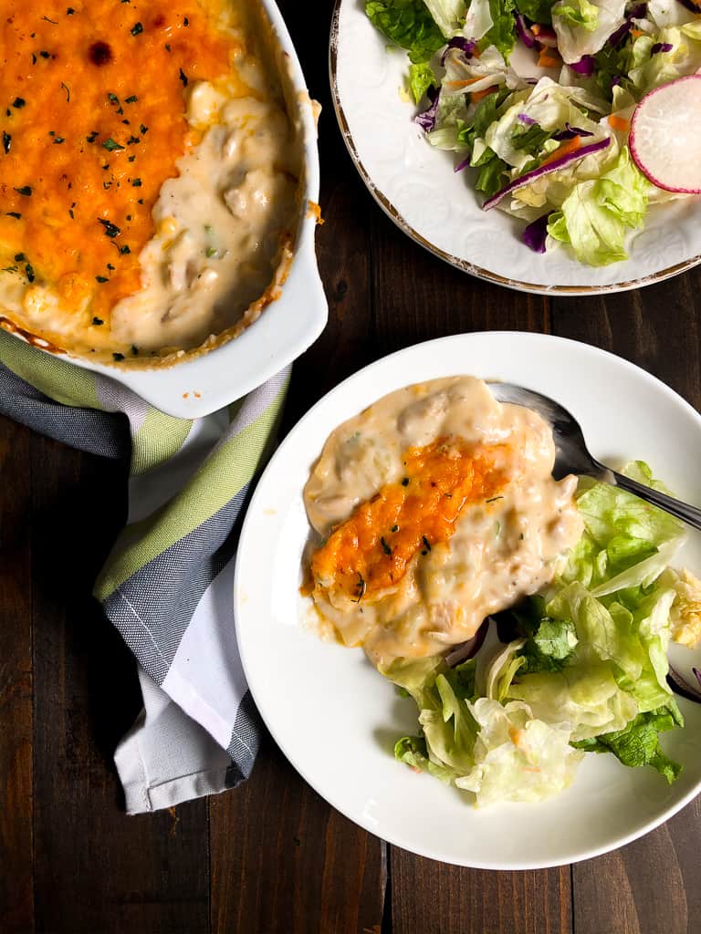 A plate of Chicken and Cheese with a side salad