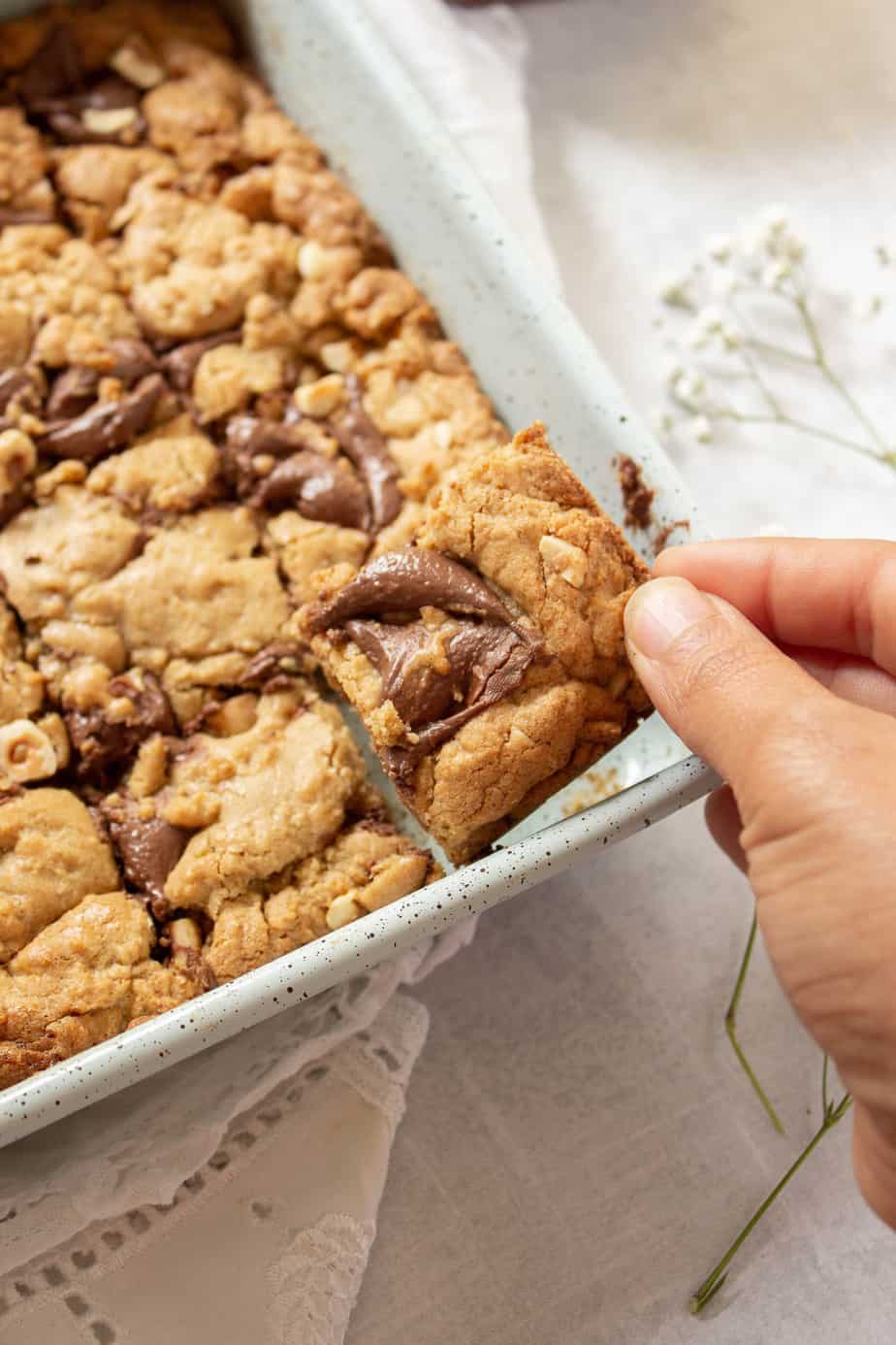 a piece of Nutella Blondie being pulled out from a pan