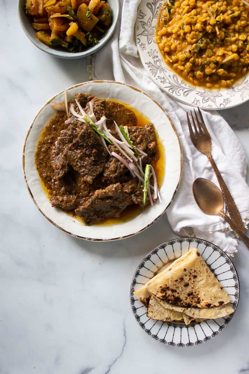 top down view of a meal featuring pasanday, daal, and sabzi