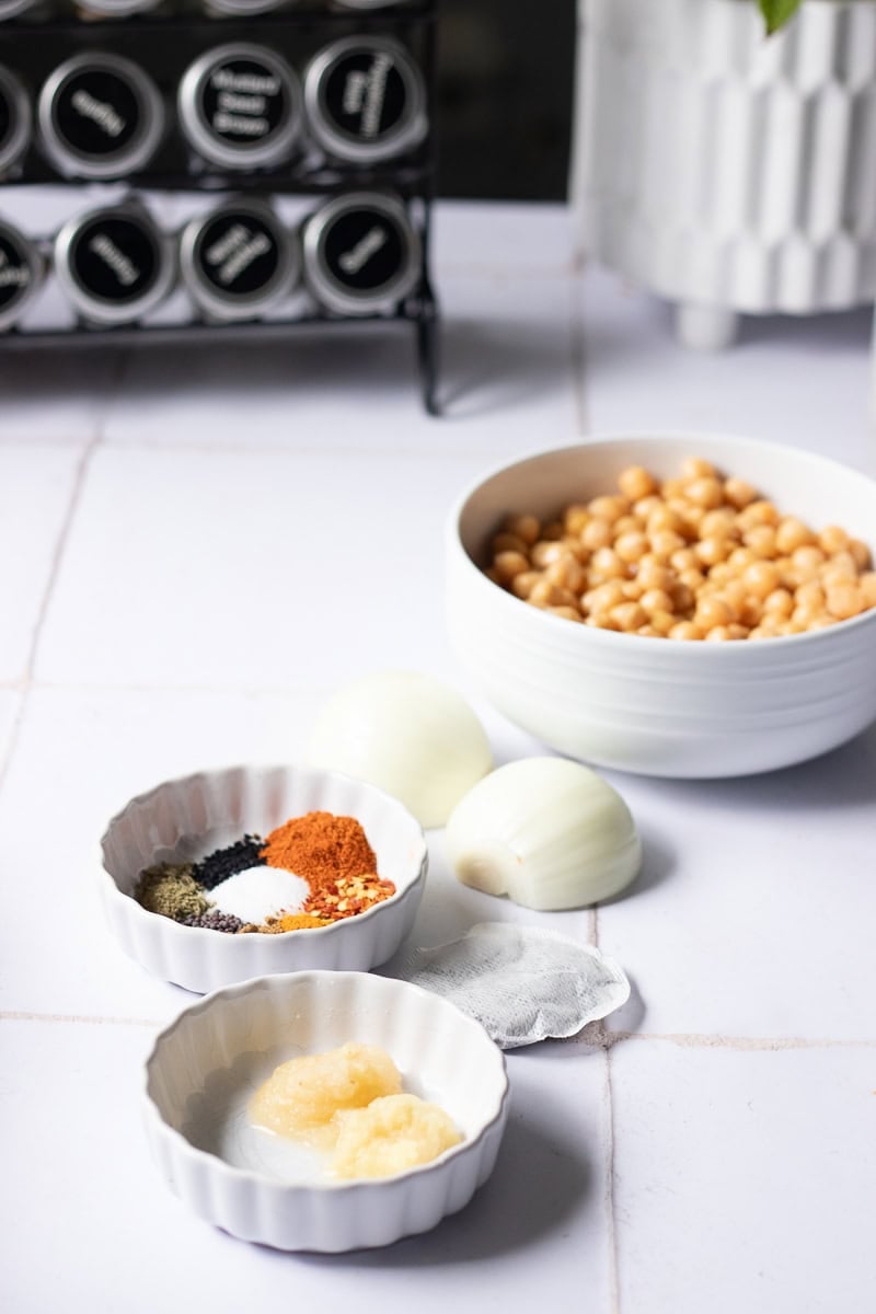 ingredients for halwa poori cholay and a spice rack in the background