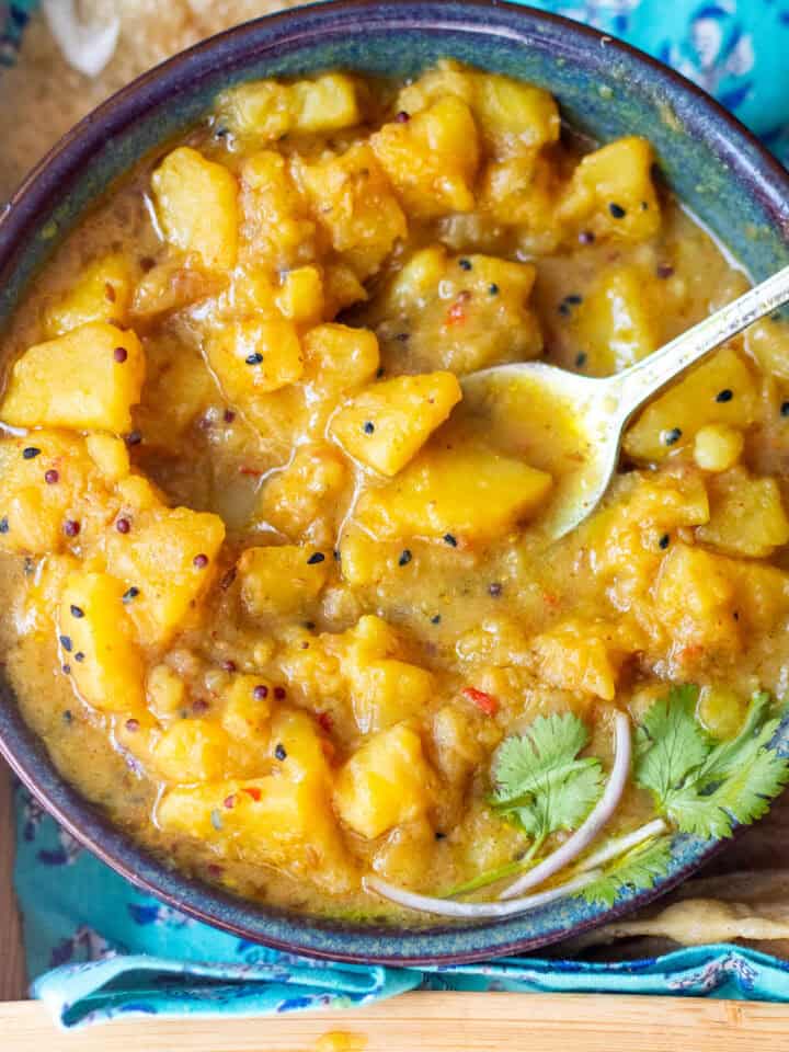 top down view of a bowl of poori walay aloo garnished with coriander