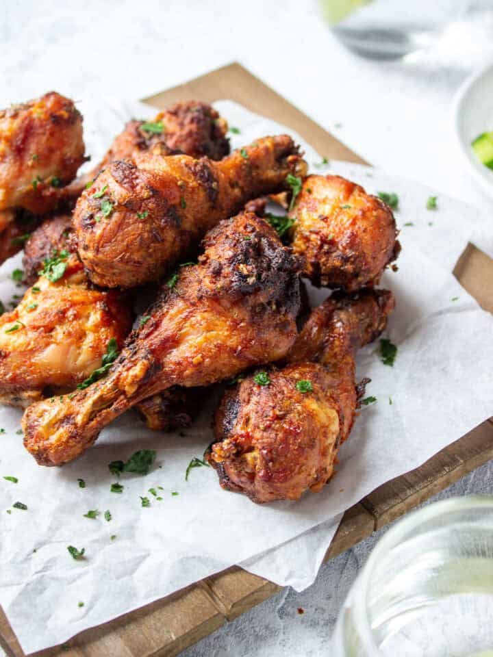 ¾ view of a a board with chicken drumsticks on top