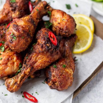 ¾ view of a a board with chicken drumsticks on top