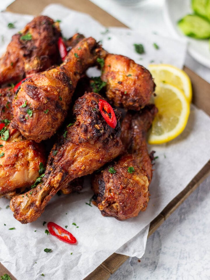 ¾ view of a a board with chicken drumsticks on top