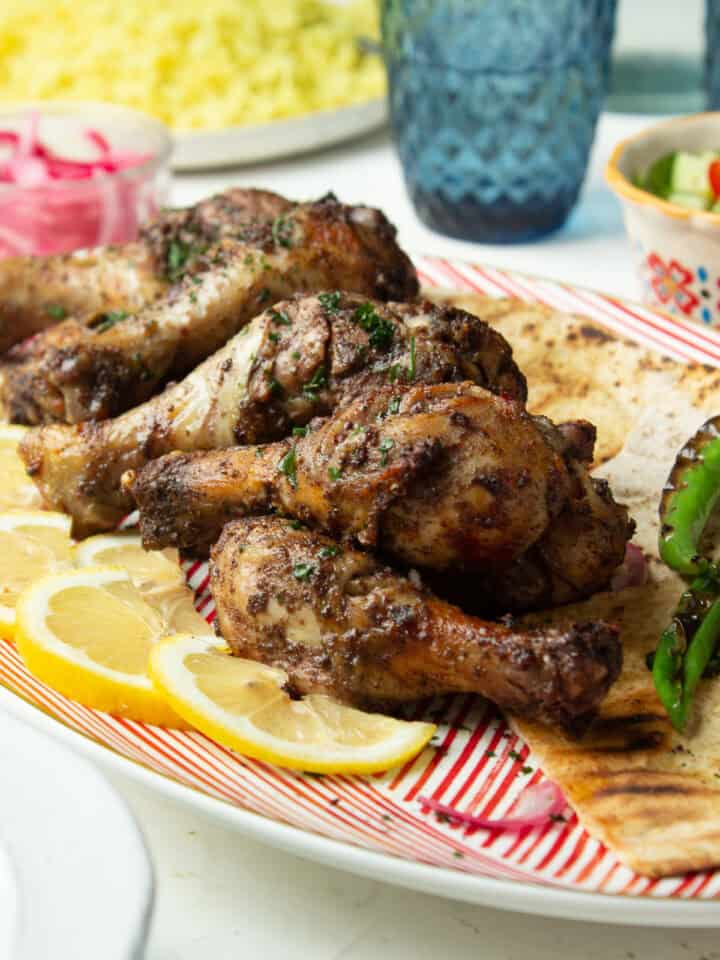 air fryer sumac chicken drumsticks on a plate with slices of lemon