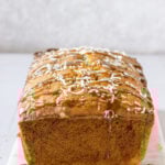 a coconut cake loaf with shredded coconut and caramel sauce drizzle