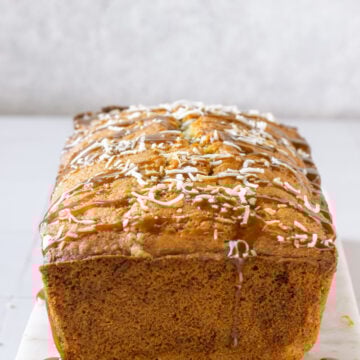 a coconut cake loaf with shredded coconut and caramel sauce drizzle