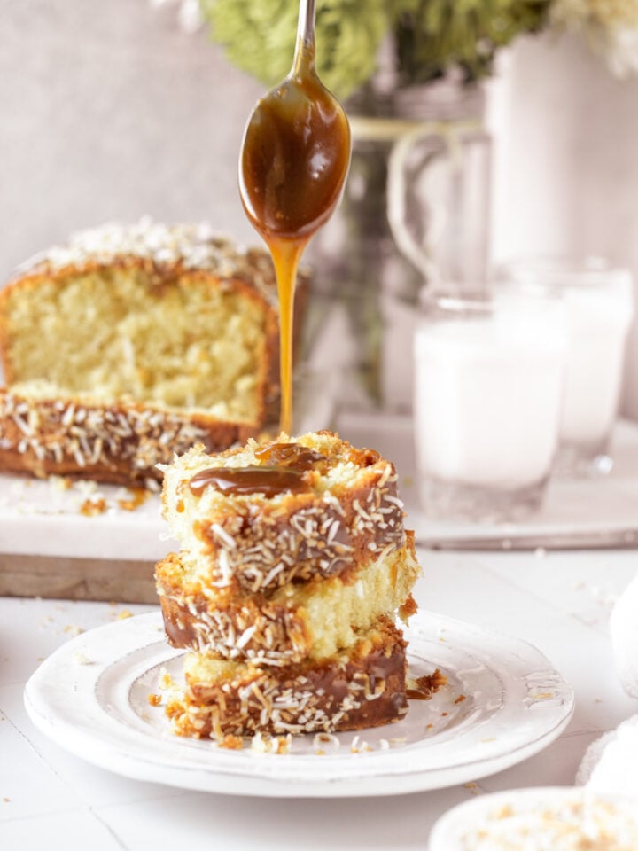stack of coconut cake slices, caramel sauce drizzling ove top