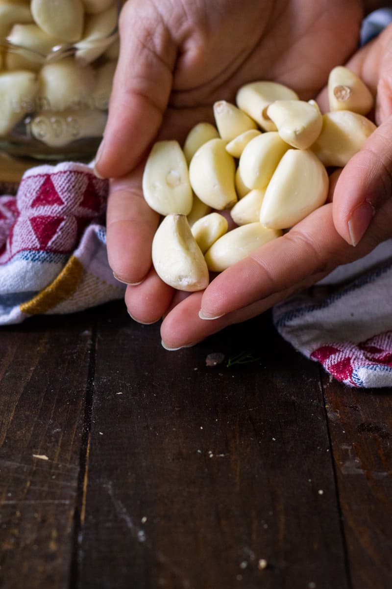 a hand holding garlic cloves
