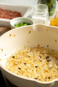 sauted onions and whole spices in a pan