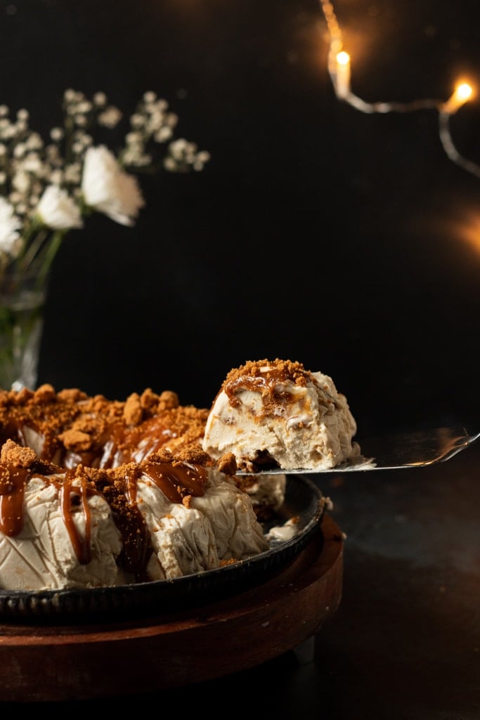 Biscoff ice cream cake with a slice being taken out.