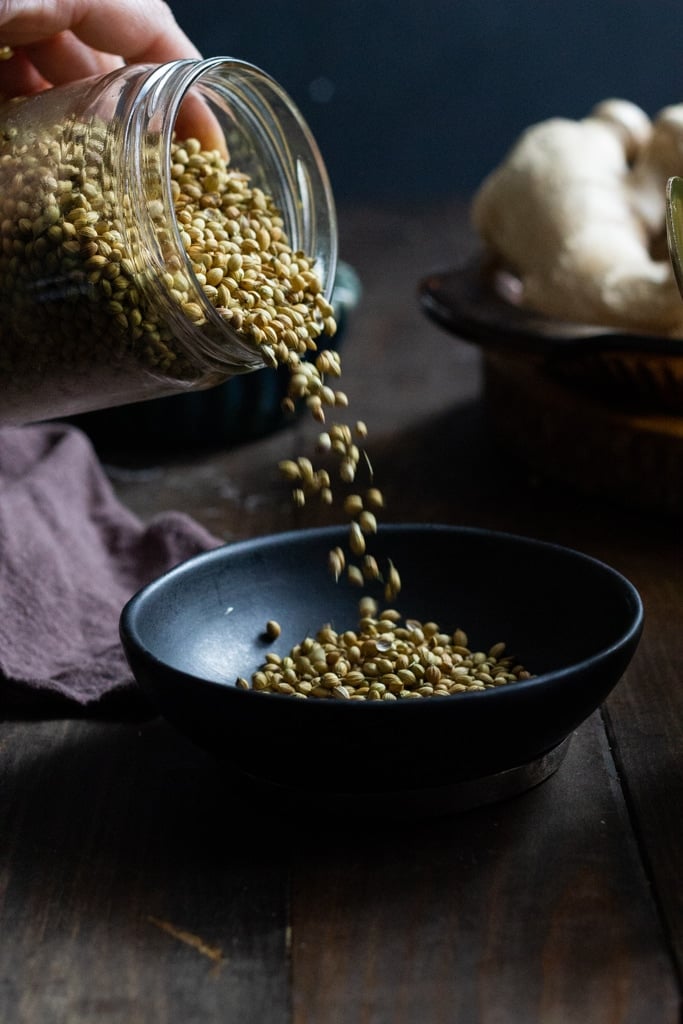 Coriander Seeds being poured into a bowl