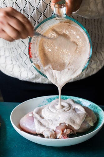 marinade being poured over chicken