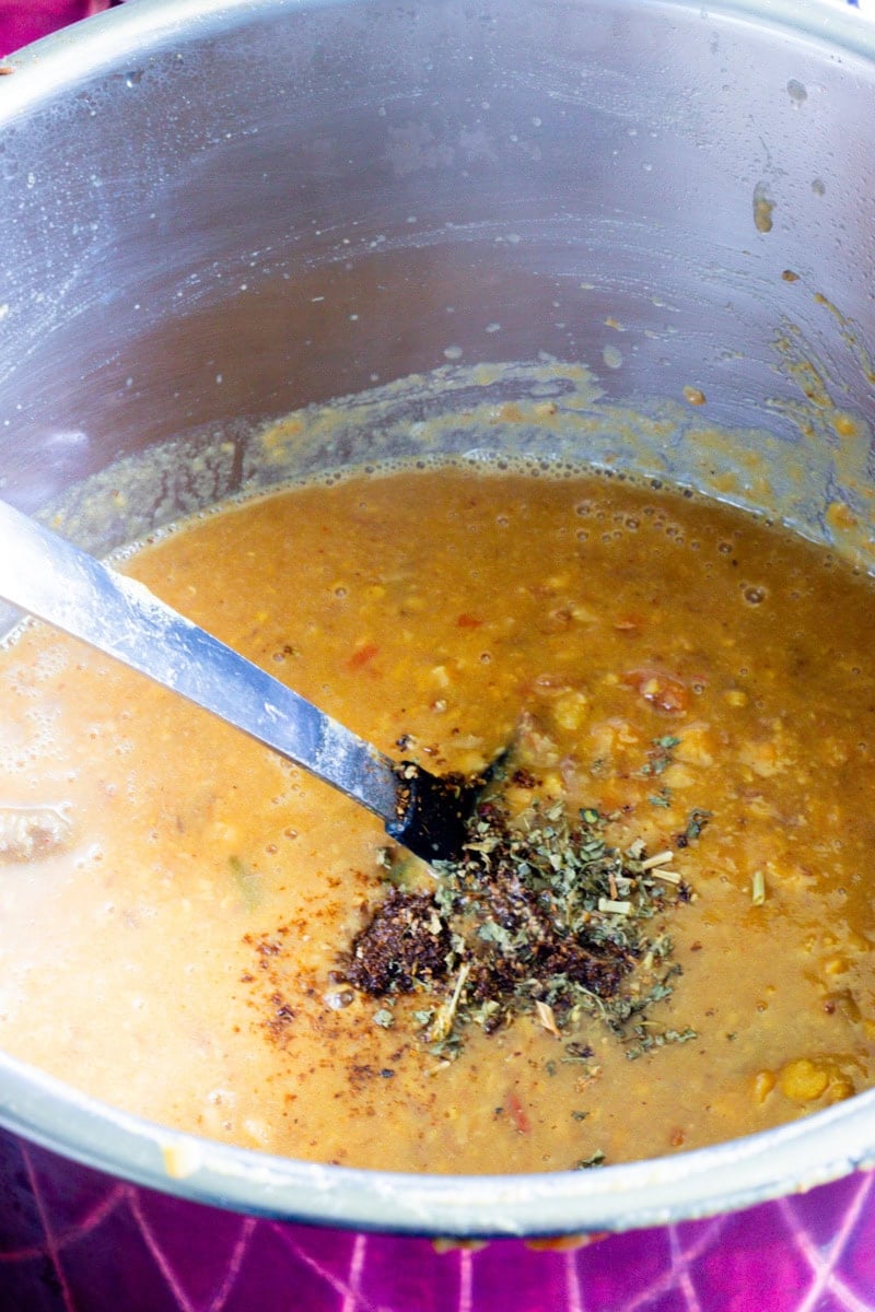 methi and ground whole spices added to a pot of dal gosht