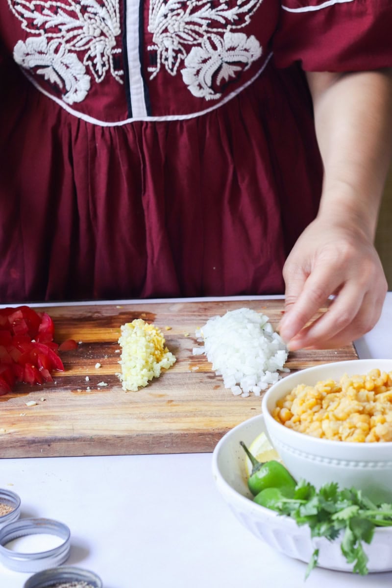 chopping ingredients for dal fry - tomatoes, ginger garlic, and onions
