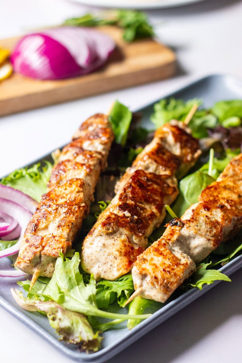 three malai boti skewers on greens