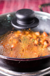 tomato masala cooking with lid on