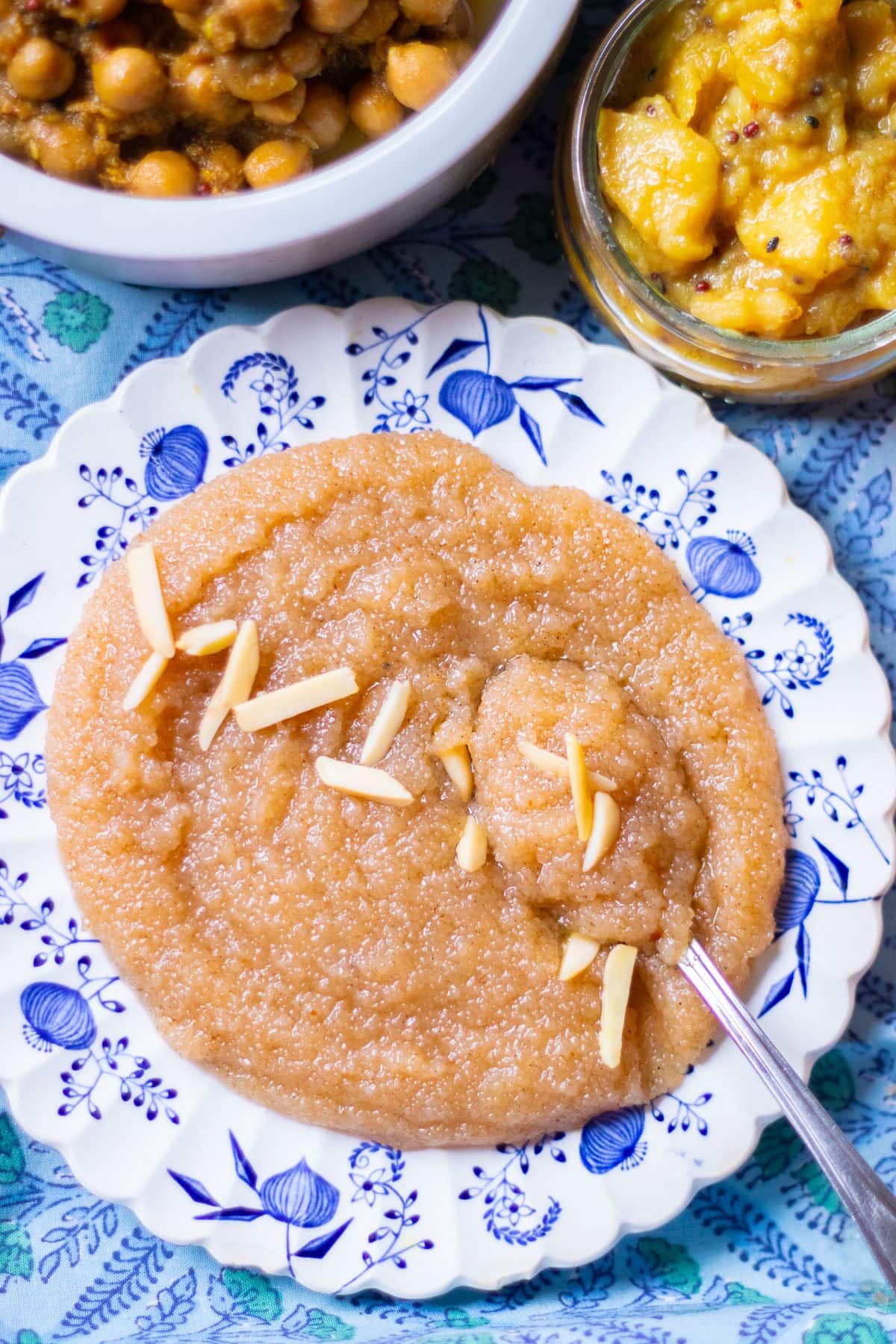 sooji ka halwa in a plate with chana and aloo in separate dishes
