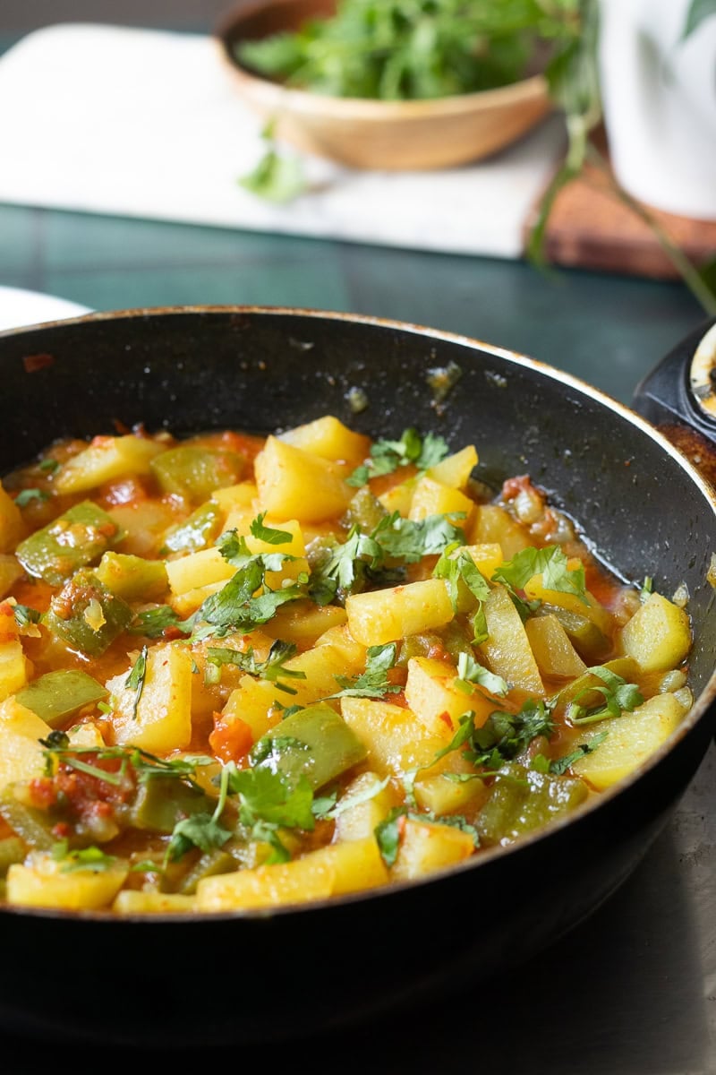 a wok with aloo capsicum sabzi in it